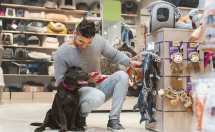 Homem com seu cachorro escolhendo um brinquedo no Pet Shop