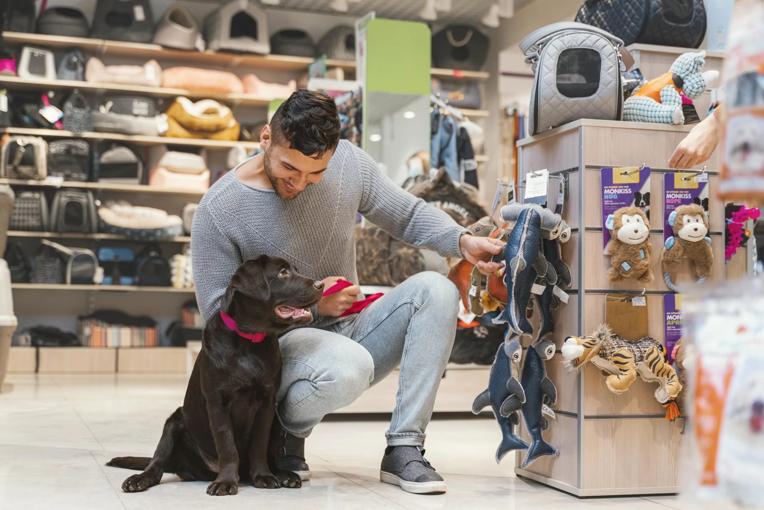 Homem com seu cachorro escolhendo um brinquedo no Pet Shop